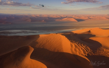 084-SV_10P8278 On Photo-Mission. Helicopter Flying Over Vast Expanse of Sand Dunes of Sossusvlei. Namib-Naukluft National Park, Namibia. Aerial.