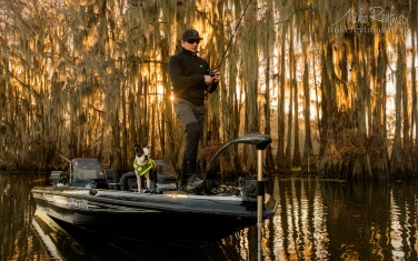 Fisherman-in-Bald-Cypress-Trees-alley.-Government-Ditch,-Lake-Caddo,-Texas,-US