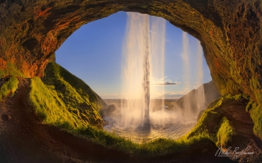 Seljalandsfoss-waterfall-bathed-in-the-light-of-the-midnight-sun.-Iceland,-South-Coast,-Route-1.
